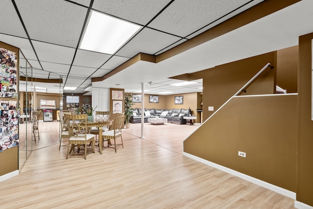 dining space with wood finished floors, a wealth of natural light, and a paneled ceiling