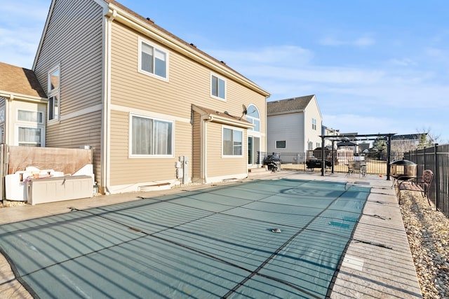 back of property featuring a fenced in pool, a patio, and a fenced backyard