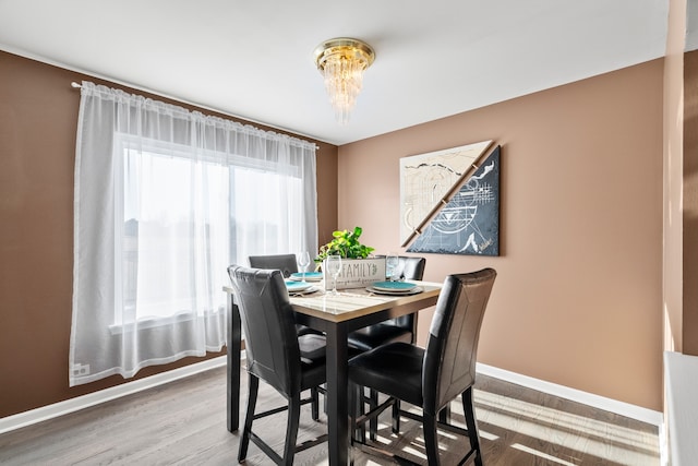 dining area with wood finished floors, baseboards, and a chandelier