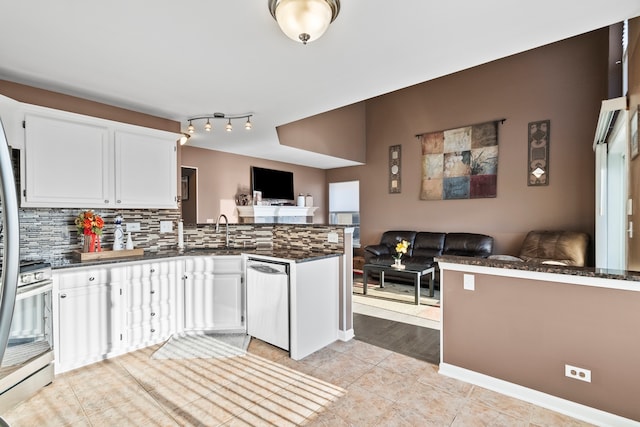 kitchen featuring dishwashing machine, a peninsula, decorative backsplash, white cabinets, and open floor plan