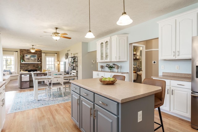 kitchen with a center island, a breakfast bar, gray cabinets, and white cabinetry