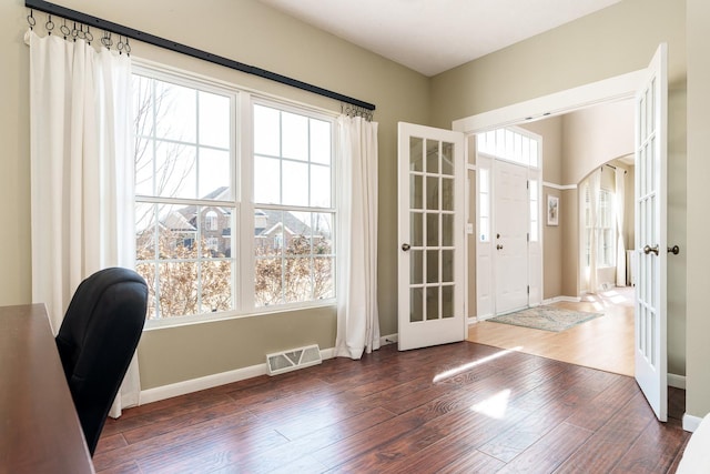 entryway with visible vents, baseboards, french doors, wood finished floors, and arched walkways