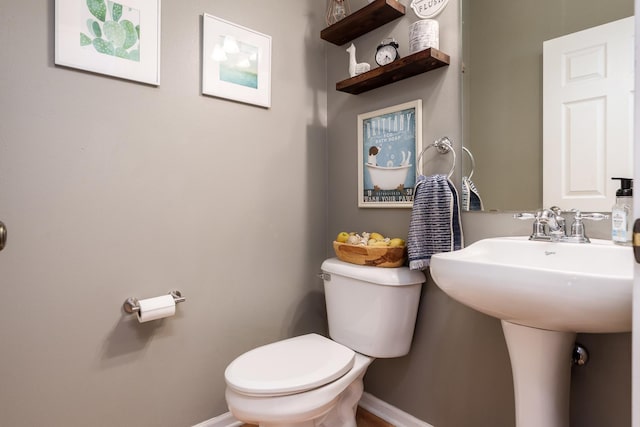 bathroom with baseboards and toilet