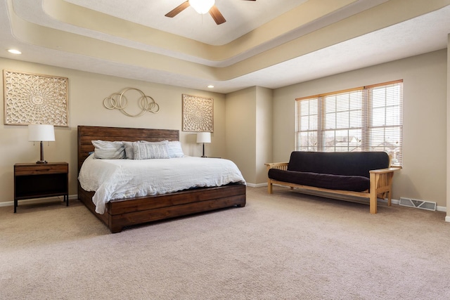 carpeted bedroom with visible vents, a ceiling fan, recessed lighting, baseboards, and a raised ceiling