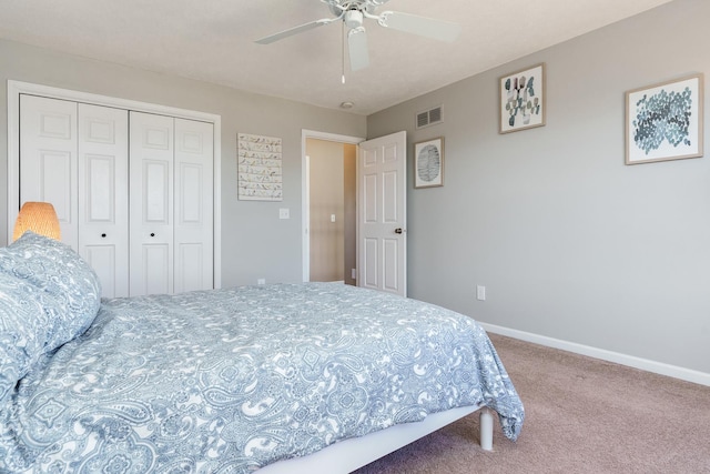 carpeted bedroom with a closet, visible vents, a ceiling fan, and baseboards