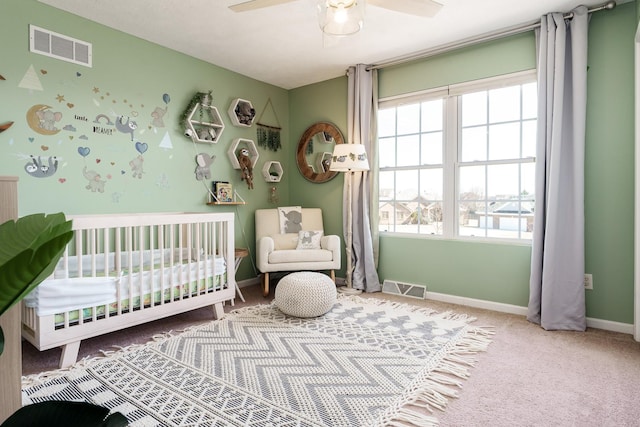 bedroom with visible vents, carpet flooring, a crib, and baseboards