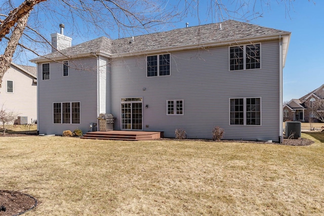 rear view of house featuring a yard, central AC, and a chimney