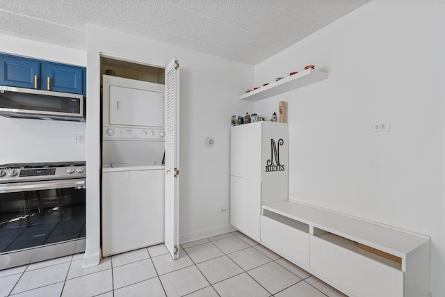 laundry room with light tile patterned flooring, laundry area, a textured ceiling, and stacked washer / drying machine