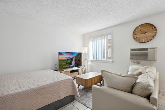 bedroom with a wall mounted air conditioner, a textured ceiling, and light tile patterned floors