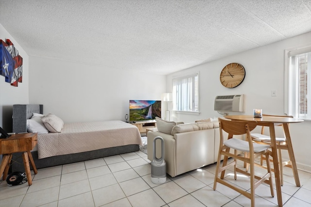 bedroom with light tile patterned flooring, a textured ceiling, and a wall mounted AC