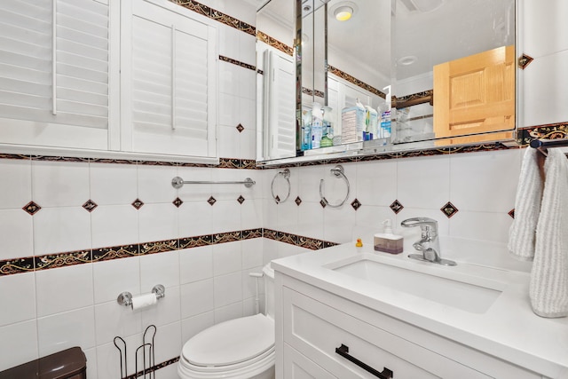 bathroom featuring toilet, tile walls, and vanity