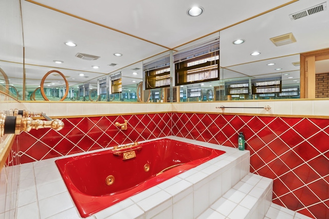 bathroom with tile patterned flooring, recessed lighting, a tub with jets, and visible vents