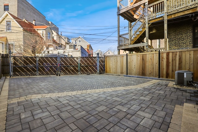 view of patio / terrace with fence, central AC, and a gate