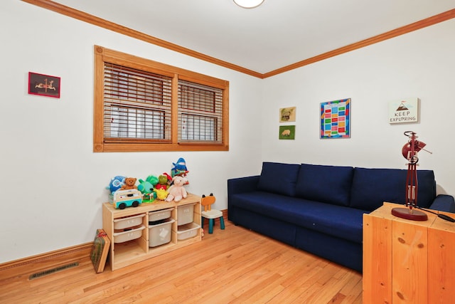 living room with visible vents, baseboards, wood finished floors, and ornamental molding