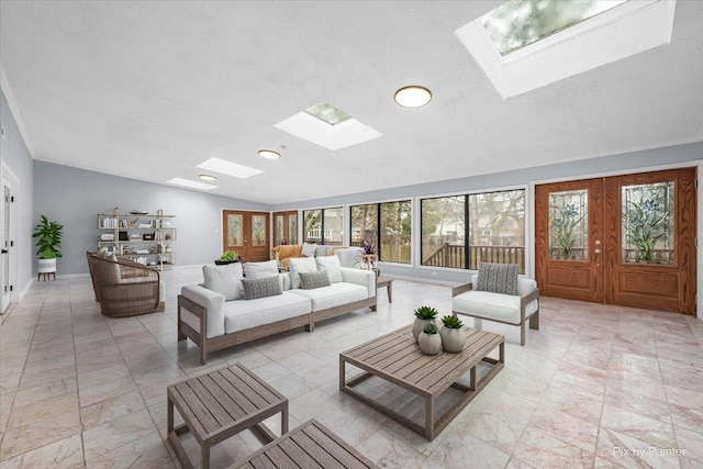 living area with french doors, a skylight, and baseboards