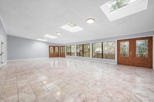 interior space with a skylight, french doors, and baseboards