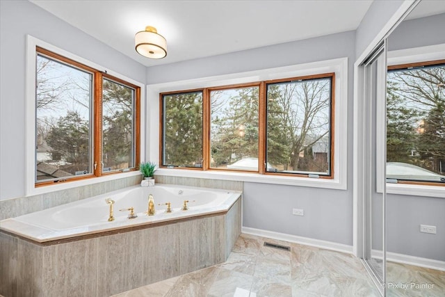 bathroom featuring a bath, visible vents, marble finish floor, and baseboards