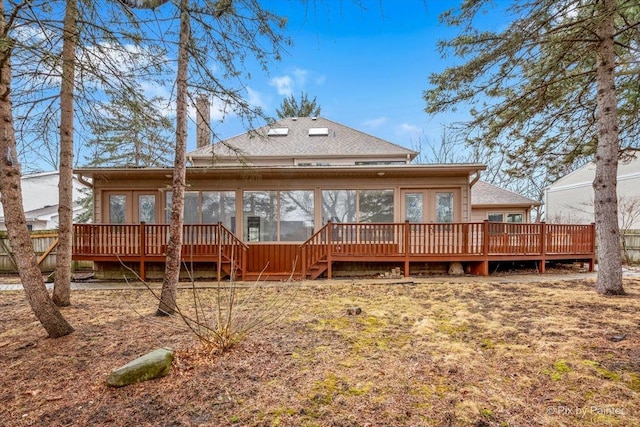 back of house featuring a deck, stairs, and a shingled roof