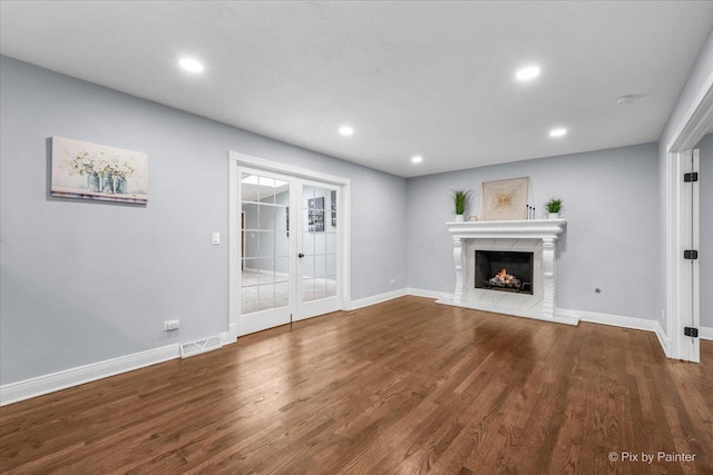 unfurnished living room featuring recessed lighting, baseboards, wood finished floors, and a fireplace