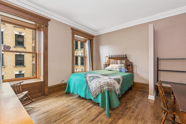 bedroom with wood finished floors, baseboards, and ornamental molding