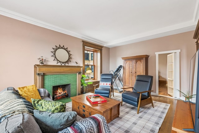 living room featuring a tiled fireplace, light wood-type flooring, and baseboards