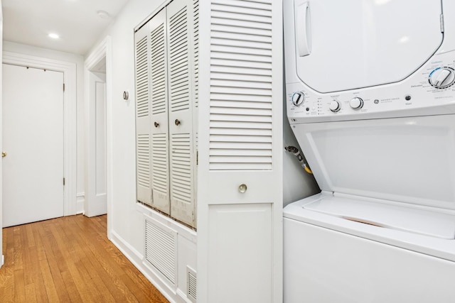 laundry room with light wood finished floors, laundry area, and stacked washer / dryer