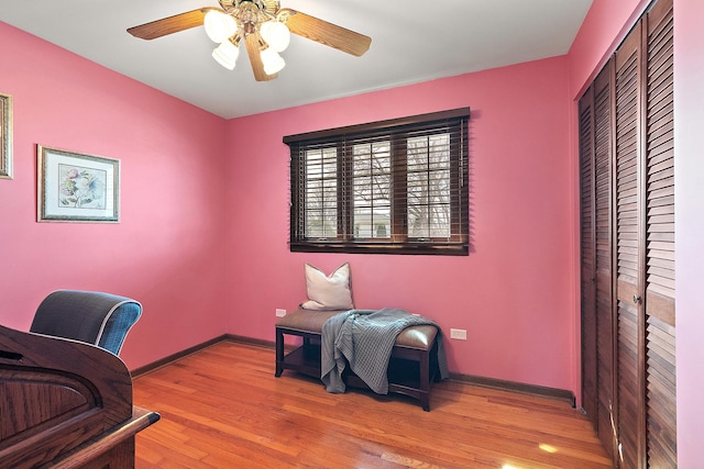 office space featuring baseboards, wood finished floors, and a ceiling fan