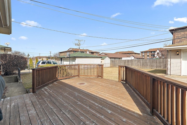 deck featuring an outbuilding, a fenced backyard, a storage shed, a lawn, and a residential view