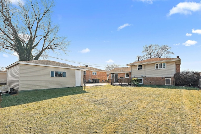 back of house with a deck, an outbuilding, a yard, and brick siding