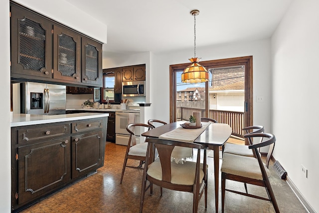 dining area with baseboards and dark floors