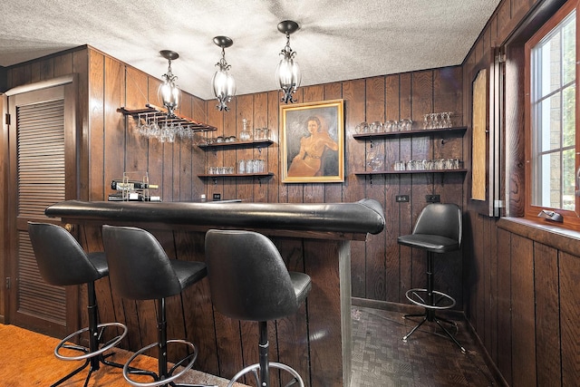 bar featuring a wealth of natural light, wood walls, and bar area