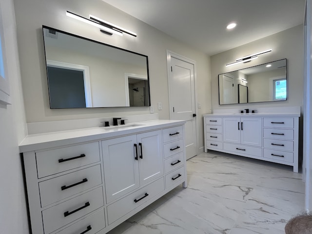 bathroom featuring two vanities, recessed lighting, a sink, walk in shower, and marble finish floor