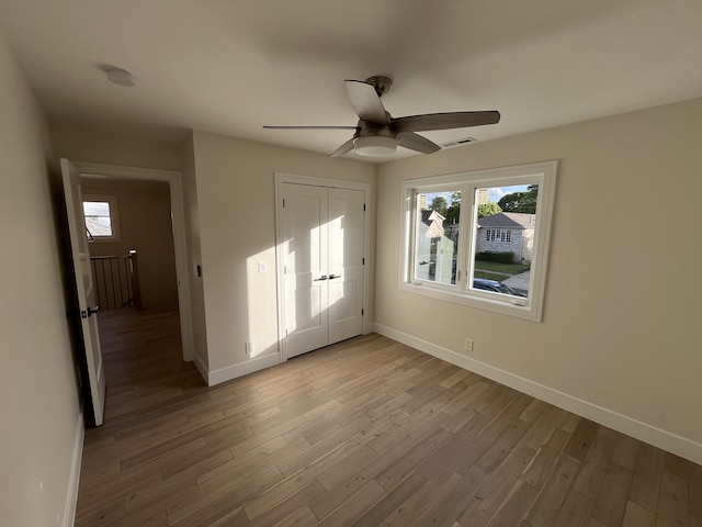 unfurnished bedroom featuring visible vents, light wood-style flooring, baseboards, and multiple windows