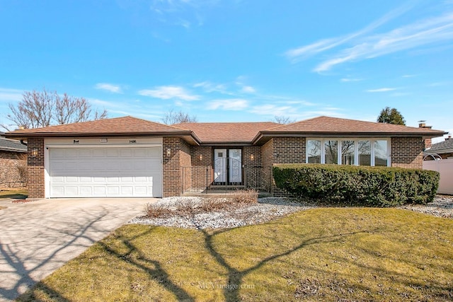 ranch-style home featuring a garage, brick siding, concrete driveway, and a front lawn