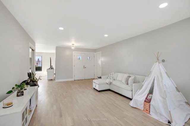 living area featuring recessed lighting, baseboards, and light wood finished floors