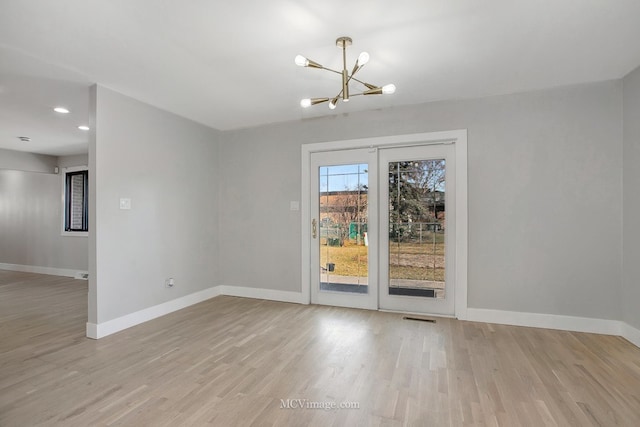 unfurnished dining area featuring wood finished floors, baseboards, visible vents, an inviting chandelier, and recessed lighting