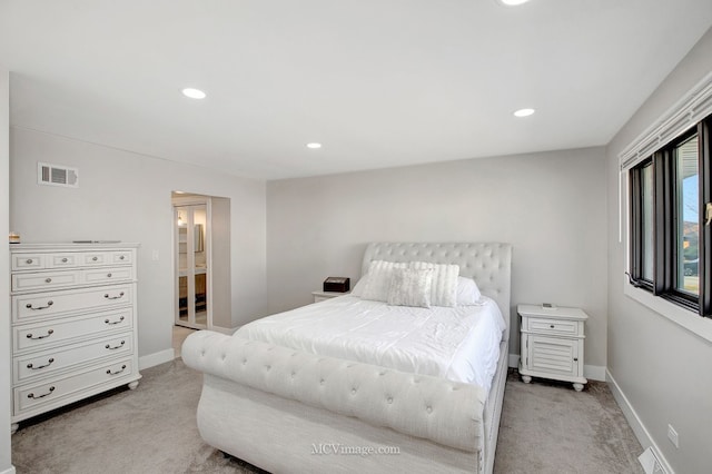 bedroom with visible vents, light carpet, and baseboards