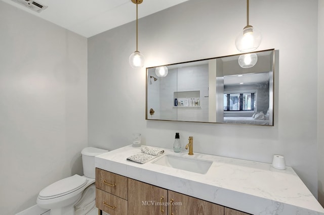 bathroom featuring visible vents, toilet, and vanity