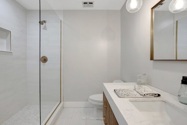 bathroom with visible vents, toilet, a tile shower, baseboards, and vanity