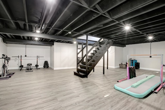 workout room featuring baseboards and wood finished floors