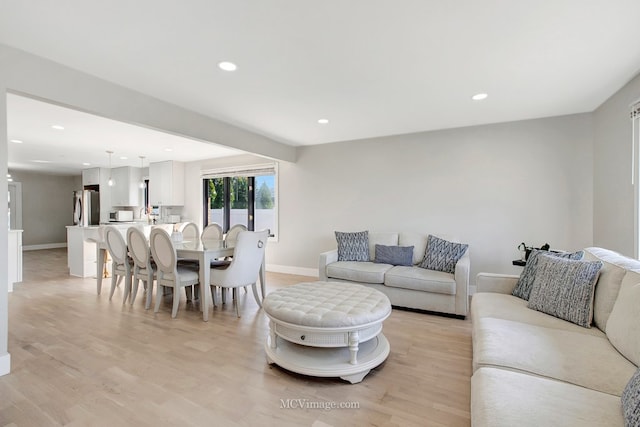 living room with recessed lighting, light wood-type flooring, and baseboards