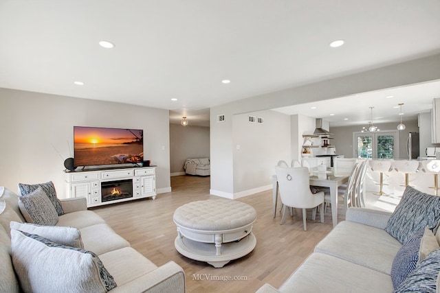 living room with light wood-style flooring and recessed lighting