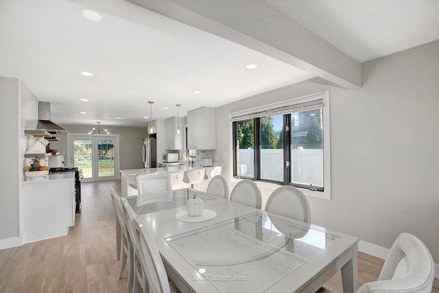 dining area with a notable chandelier, recessed lighting, light wood-style flooring, and baseboards