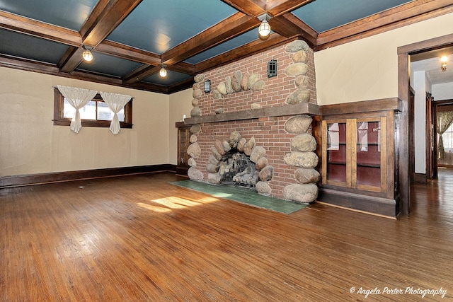 unfurnished living room with baseboards, beamed ceiling, a fireplace, wood finished floors, and coffered ceiling