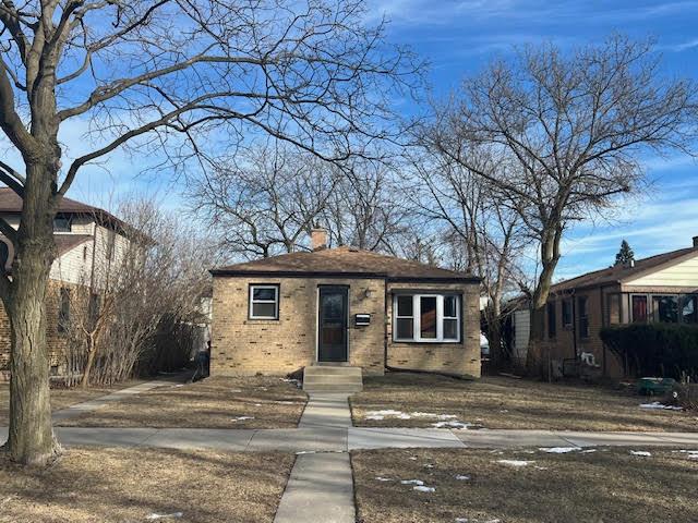 bungalow-style house with brick siding and a chimney