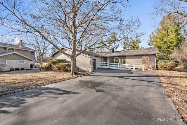 mid-century inspired home featuring aphalt driveway