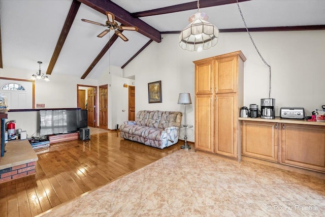 living area with light wood finished floors, beam ceiling, high vaulted ceiling, and ceiling fan