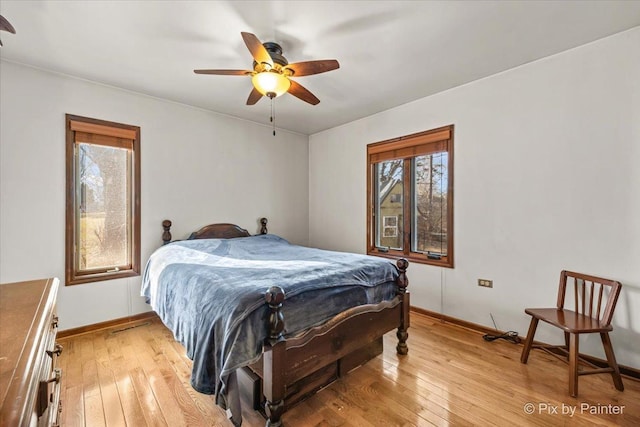 bedroom with baseboards, light wood-style flooring, and a ceiling fan