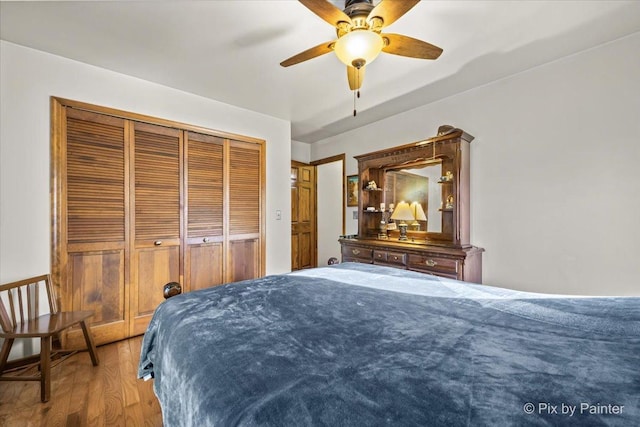 bedroom with a ceiling fan, wood finished floors, and a closet