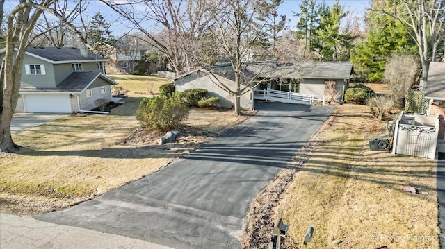 view of front of property featuring aphalt driveway and fence